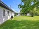 Expansive backyard with lush green grass, chain link fence, shed, and partial view of house at 5312 Kingswood Dr, Orlando, FL 32810