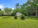 Green grass backyard with a storage shed, plants and trees providing a serene outdoor space at 5312 Kingswood Dr, Orlando, FL 32810