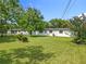 The rear of house featuring a grassy yard with tropical plants and fence at 5312 Kingswood Dr, Orlando, FL 32810