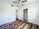 Bedroom featuring wood-look floors, white walls, ceiling fan, closet, and ensuite bathroom at 5312 Kingswood Dr, Orlando, FL 32810