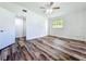 This bedroom has wood-look flooring, white walls, a ceiling fan, a window, and two doors at 5312 Kingswood Dr, Orlando, FL 32810