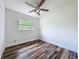 This bedroom has wood-look flooring, white walls, a ceiling fan, and a window at 5312 Kingswood Dr, Orlando, FL 32810