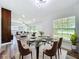 Bright dining area featuring a glass table, plush chairs, and large windows offering a view of the outdoors at 5312 Kingswood Dr, Orlando, FL 32810