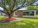 Landscaped front yard with lush green grass and a mature tree at 5312 Kingswood Dr, Orlando, FL 32810