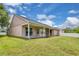 Spacious backyard featuring a covered patio, perfect for outdoor entertaining and relaxation on a sunny day at 651 Regina Cir, Oakland, FL 34787
