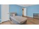 Bright blue bedroom with hardwood floors, neutral furniture, and ample natural light at 651 Regina Cir, Oakland, FL 34787