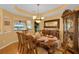 Formal dining room with a large wooden table, ornate chandelier, and decorative china cabinet at 651 Regina Cir, Oakland, FL 34787