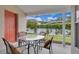 Patio featuring a glass table, seating, a red door, and a view of the lawn at 651 Regina Cir, Oakland, FL 34787