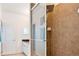 Tiled shower with glass door and rainfall shower head, as well as view of the bathroom vanity at 6808 Goldflower Ave, Harmony, FL 34773