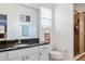 Well-lit bathroom features a granite countertop, modern fixtures, and walk-in shower with glass door at 6808 Goldflower Ave, Harmony, FL 34773