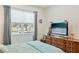 Bright bedroom featuring a large window and wooden dresser at 6808 Goldflower Ave, Harmony, FL 34773