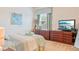 Bedroom with a queen bed, dresser, and large window with blinds at 6808 Goldflower Ave, Harmony, FL 34773