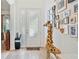 Bright entryway featuring tile flooring, a decorative giraffe, and a wall adorned with framed pictures at 6808 Goldflower Ave, Harmony, FL 34773