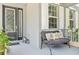 Cozy front porch with comfortable seating, decorative pillows, stylish lanterns and lovely flowering plants at 6808 Goldflower Ave, Harmony, FL 34773
