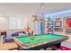 Spacious game room with a beautiful pool table, soft couch, and unique lighting fixtures at 6808 Goldflower Ave, Harmony, FL 34773