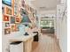 Bright hallway with wooden floors and Gathering photos leading to a naturally lit living area with a comfortable gray couch at 6808 Goldflower Ave, Harmony, FL 34773