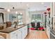 Spacious kitchen with island seating, white cabinetry, stainless appliances, and open view to the backyard dining area at 6808 Goldflower Ave, Harmony, FL 34773