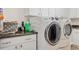 Well-lit laundry room featuring modern appliances, sleek countertops, and ample cabinet space for organized storage at 6808 Goldflower Ave, Harmony, FL 34773