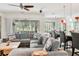 Open-concept living room with large sectional, leading to a dining area and an expansive screened outdoor space at 6808 Goldflower Ave, Harmony, FL 34773