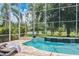 Inviting screened pool area with stylish lounge chairs, offering a serene spot for relaxation and outdoor enjoyment at 6808 Goldflower Ave, Harmony, FL 34773