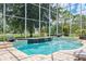 Beautiful pool with water feature surrounded by a screened-in patio and lush landscaping at 6808 Goldflower Ave, Harmony, FL 34773