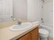 Bathroom with vanity, sink, mirror, toilet, and a shower-tub combination with white tiled walls at 7638 Long Island Dr, Kissimmee, FL 34747