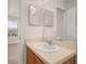 Bathroom with vanity, sink, mirror, toilet, and a view to a bedroom through the doorway at 7638 Long Island Dr, Kissimmee, FL 34747