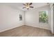 A clean bedroom with two windows, fan and luxury vinyl plank flooring at 7638 Long Island Dr, Kissimmee, FL 34747
