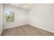 Bright bedroom features light wood flooring and a ceiling fan, bathed in natural light from a window at 7638 Long Island Dr, Kissimmee, FL 34747