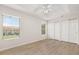 This bedroom features two large windows, light wood flooring, a ceiling fan, and a spacious double closet at 7638 Long Island Dr, Kissimmee, FL 34747