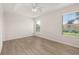 Bright and airy bedroom with two windows, light wood flooring, and a modern ceiling fan at 7638 Long Island Dr, Kissimmee, FL 34747