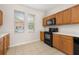 Well-lit kitchen features wooden cabinets and black appliances at 7638 Long Island Dr, Kissimmee, FL 34747