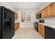 Kitchen features stainless steel refrigerator, black oven, and beautiful wood cabinets at 7638 Long Island Dr, Kissimmee, FL 34747
