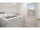 The laundry room has a washer, dryer and a window at 7638 Long Island Dr, Kissimmee, FL 34747