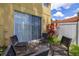 Outdoor patio with black metal chairs, concrete flooring, sliding glass doors and a white privacy fence at 7638 Long Island Dr, Kissimmee, FL 34747