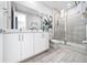 Bright bathroom with double sink, vanity, and glass shower at 7920 Draw St, Reunion, FL 34747