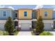Charming townhouse with a one-car garage, colorful facade, and well-maintained landscaping, creating an inviting curb appeal at 7920 Draw St, Reunion, FL 34747