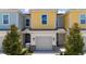 Charming townhouse with a one-car garage, colorful facade, and well-maintained landscaping, creating an inviting curb appeal at 7920 Draw St, Reunion, FL 34747