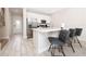 Well-lit kitchen featuring white cabinets, stainless steel appliances, and a breakfast bar with modern seating at 7920 Draw St, Reunion, FL 34747