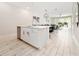 Bright, modern kitchen with white cabinets, island, and stainless steel appliances, open to the living area at 7920 Draw St, Reunion, FL 34747