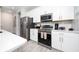 Modern kitchen with stainless steel appliances, white cabinetry, and stylish backsplash for a contemporary look at 7920 Draw St, Reunion, FL 34747
