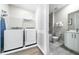 A laundry room with washer, dryer and next to a bathroom with a shower at 7920 Draw St, Reunion, FL 34747