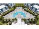 Aerial view of a community resort pool with plenty of lounge chairs and seating at 7920 Draw St, Reunion, FL 34747