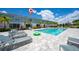 Relaxing community pool has ample lounge chairs and is surrounded by townhomes and palm trees at 7920 Draw St, Reunion, FL 34747