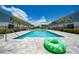 Stunning community pool is surrounded by pavers, lounge chairs, and swaying palm trees at 7920 Draw St, Reunion, FL 34747
