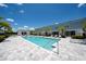 The community swimming pool is surrounded by palm trees, lounge chairs, and beautiful pavers at 7920 Draw St, Reunion, FL 34747