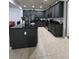 Modern kitchen with black cabinets, granite countertops, stainless steel appliances, and tiled floors at 7971 Brofield Ave, Windermere, FL 34786