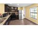 Well-equipped kitchen with dark cabinets, modern appliances, granite countertops, and a window with natural light at 8 Orchid Ct, Kissimmee, FL 34759