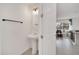 Bright bathroom features a pedestal sink, tile floors, and open doorway to the rest of the home at 816 Longboat Dr, Davenport, FL 33896