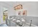 Bright dining area features a glass table, seating for eight, and modern hanging light fixtures at 816 Longboat Dr, Davenport, FL 33896